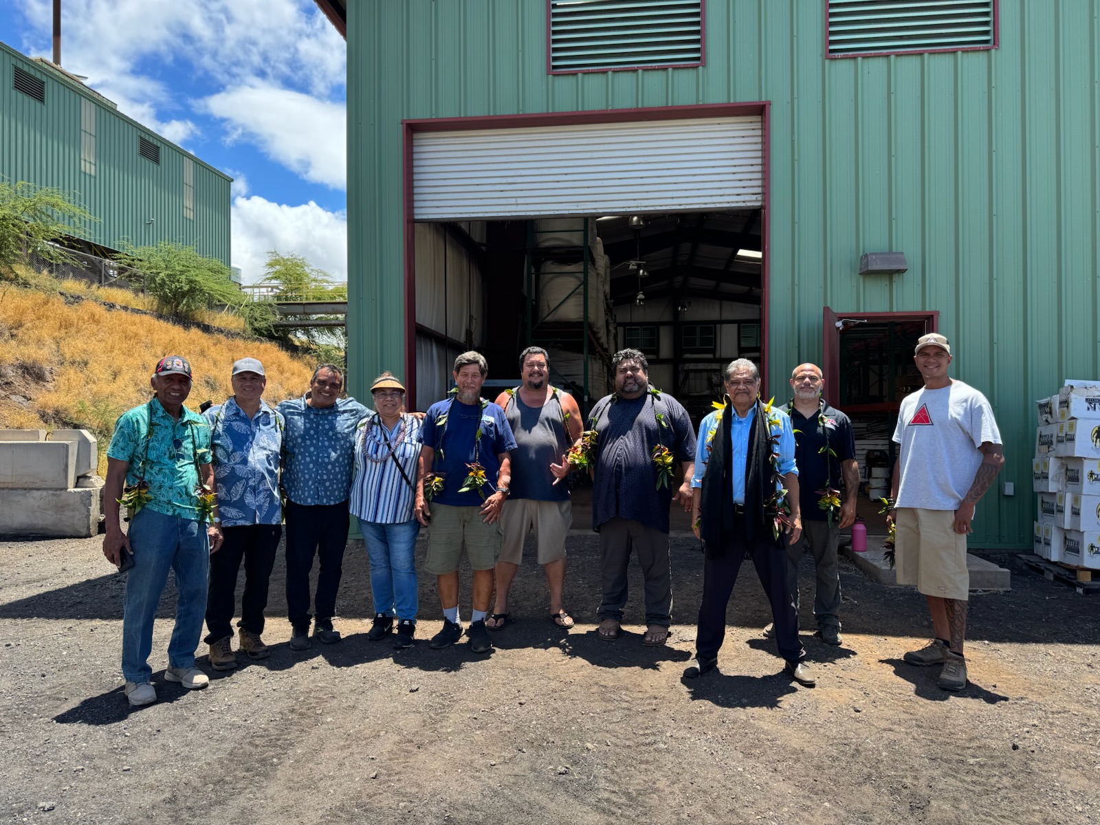 AGH team and community partners gathered at the Kawaihae plant, wearing lei